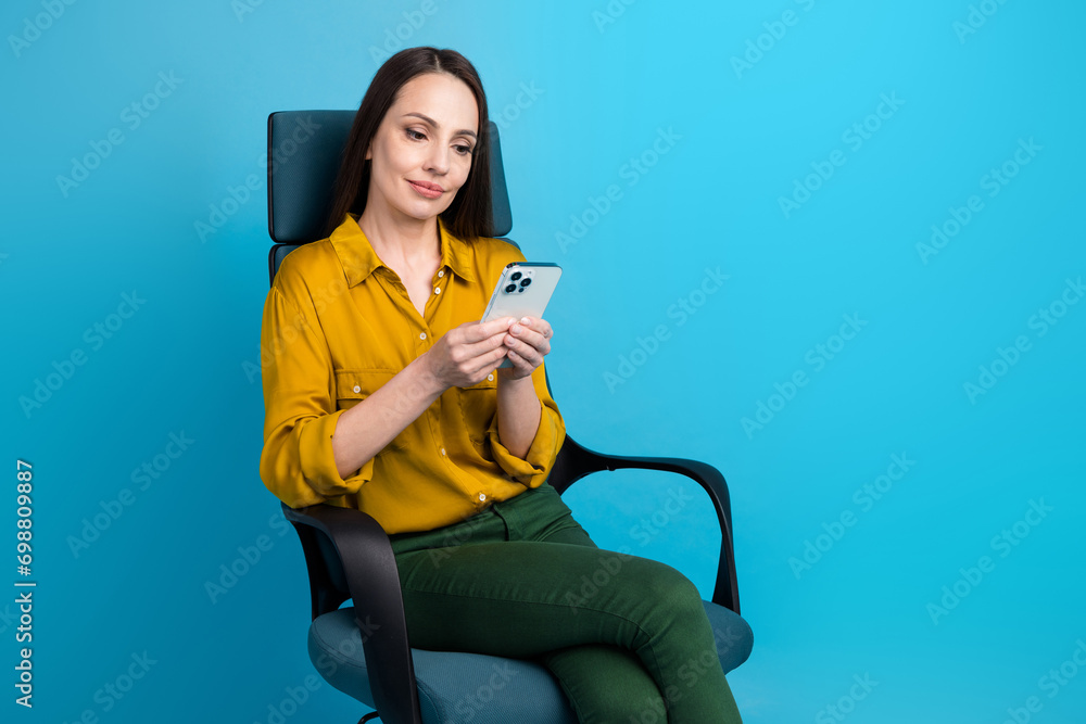 Wall mural Photo of adorable pretty lady wear yellow shirt communicating modern gadget empty space isolated blue color background