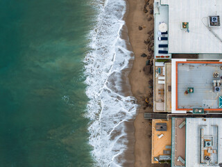 Malibu beach aerial view in California near Los Angeles, USA. Waves hitting the shore near...