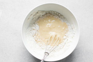 vanilla almond muffins batter in a white mixing bowl, almond muffins batter in a white ceramic...