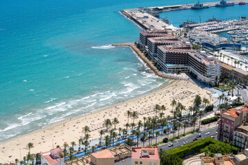 Naklejka premium Beach with people lying and swimming, on the sand and in the sea, near the Alicante port. High quality photo