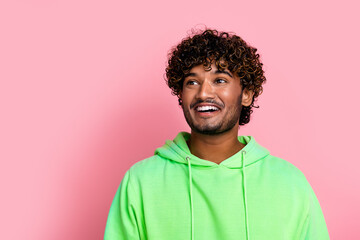 Fototapeta na wymiar Portrait of funny guy in green hoodie indian curly hair model smile looking empty space barbershop isolated on pink color background