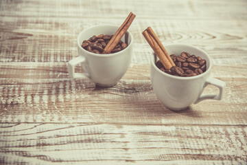 Aromatic coffee seeds and a cup of coffee on a wooden table