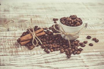 Aromatic coffee seeds and a cup of coffee on a wooden table