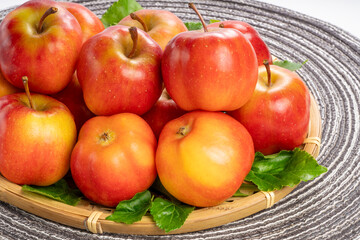 Fresh red star apple in Bamboo basket on Brown background, Korea Star Apple in wooden basket on Brown placemat.