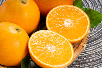 Fresh Orange fruit on wooden basket on wooden background, Japanese Orange with slices on wooden Background.
