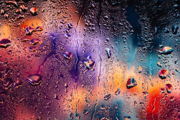 Raindrops on the window. Water drops on glass. Abstract background. Multicolored smoke. Drops...