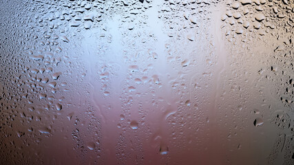 Drops of water on the glass. Drops of rain on the window. Abstract background. Colorful spots. Texture of drops
