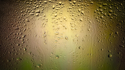 Raindrops on the window. Water drops on glass. Abstract background. Multi-colored spots. Texture of drops. Selective focus.