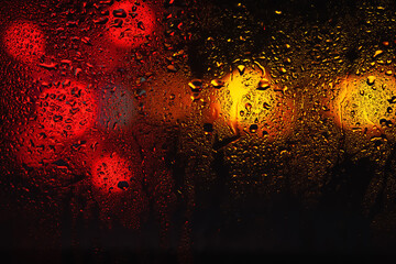 Raindrops on the window. Water drops on glass. Abstract background. Street lights. Drops texture
