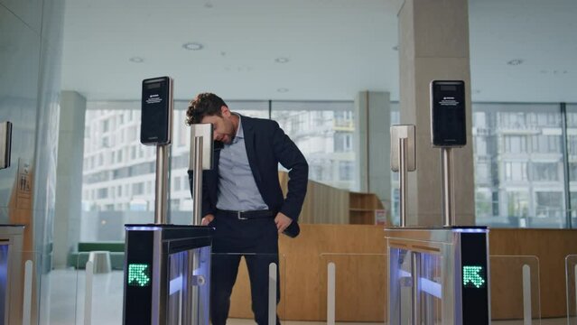 Office worker running entrance office with automatic gates talking cellphone.