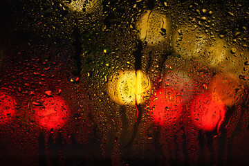 Drops of rain on the window. Drops of water on the glass. Abstract background. Street lights....