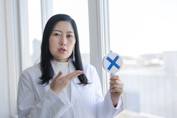 バツを出す白衣女性
