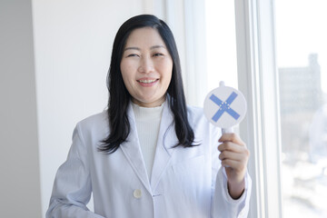 バツを出す白衣女性