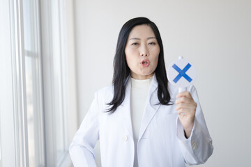 バツを出す白衣女性