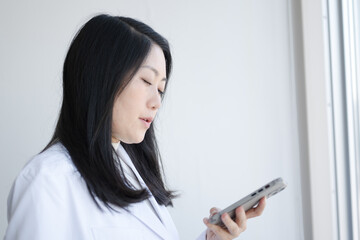 スマホを使う白衣女性