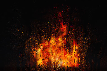 Drops of rain on the window. Drops of water on the glass. Abstract background. Fire flame. Texture of drops. Selective focus - obrazy, fototapety, plakaty
