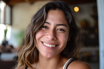 Smiling beautiful young Hispanic woman looking at the camera  - obrazy, fototapety, plakaty