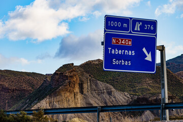 Tabernas desert landscape and road sign, Spain - obrazy, fototapety, plakaty