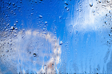 Raindrops on the window. Drops of water on the glass. Abstract background. Ferris wheel. Texture of...