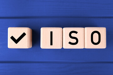 International Organization for Standardization. Cubes with check mark and abbreviation ISO on blue...