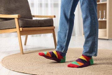 Man in stylish colorful socks and jeans indoors, closeup. Space for text