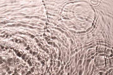 Rippled surface of clear water on beige background, top view