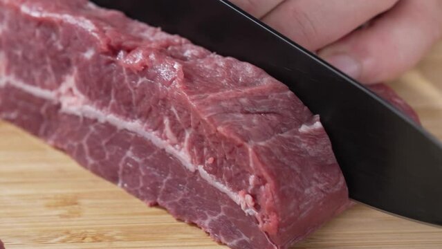 시뻘건 덩어리 생 소고기를 칼로 써는 클로즈업 영상 