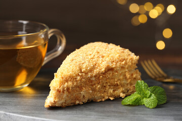 Piece of delicious Napoleon cake served on table, closeup