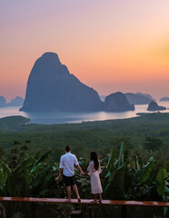 A couple of men and woman watching the sunrise at Sametnangshe viewpoint Phangnga Bay with mangrove...