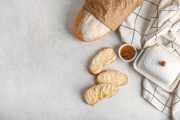 Fototapeta na wymiar Tasty bread with butter and bowl of honey on white background