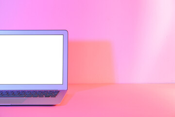 Modern laptop on pink background