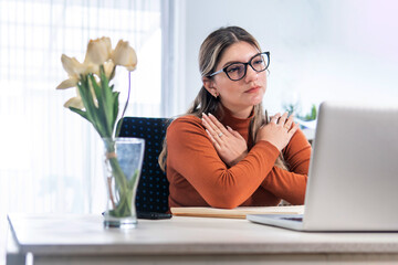 Young blonde psychologist with solidarity gesture with her arms during a video conference therapy
