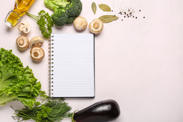 Composition with blank recipe book, fresh vegetables and herbs on light background