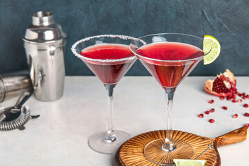 Glasses of Cosmopolitan cocktail with lime on white table