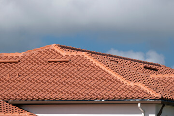 Fototapeta premium Tiled roof covering of condo building in Florida. Closeup of house rooftop covered with ceramic shingles