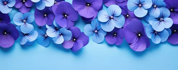 Poster Frame made of beautiful violet and purple pansy flowers on light blue background with copy space. Floral spring backdrop. Border for design greeting card or banner for wedding, mother or woman day © ratatosk