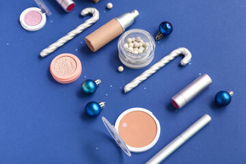 Christmas composition with different makeup products on blue background