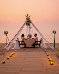 Romantic dinner on the beach in Pattaya Thailand, a couple man and woman mid age Asian woman, and a...