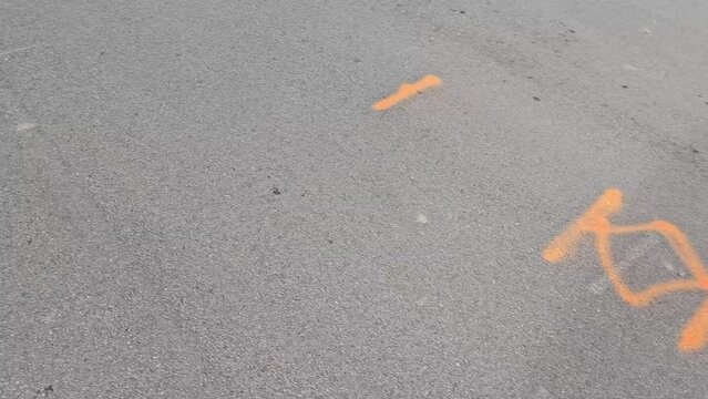 Utility company marking paint symbols painted onto asphalt road surface