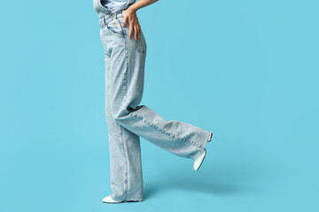 Beautiful young Asian woman in stylish denim jumpsuit on blue background, closeup - obrazy, fototapety, plakaty