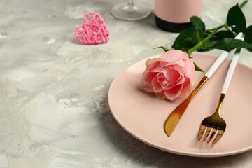 Beautiful table setting with pink rose and heart on grey background. Valentine's Day celebration