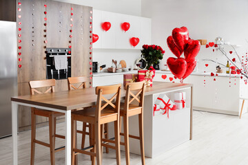 Interior of festive kitchen with wooden island table and decorations for Valentine's Day celebration