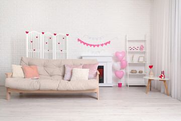 Interior of festive living room with white sofa, fireplace and decor for Valentine's Day celebration