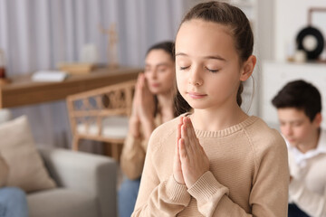 Little girl praying at home, closeup
