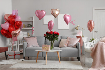 Interior of festive living room with grey sofa, heart-shaped balloons and bouquet of roses on...