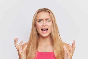 Fair-haired woman with angry expression on face crying angrily over white studio background, hard day concept, copy space