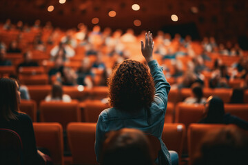 Young female Raises a Question in a Crowded Auditorium - obrazy, fototapety, plakaty