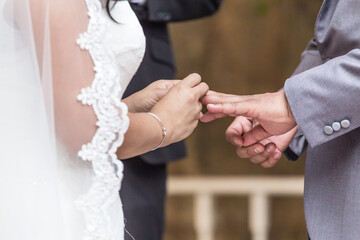 Wedding ceremony of two people holding hand and opening box to show wedding ring
