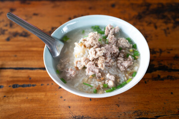 Pork Porridge with pork Pork porridge sprinkled with dried chili in a white ceramic cup.