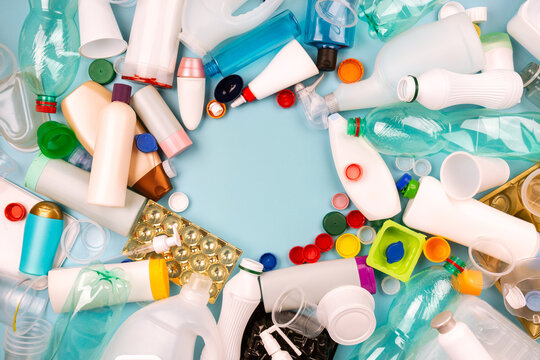 Sorted plastic garbage. PET, PP, HDPE, LDPE stuff for recycle on blue background. Eco friendly concept. Recyclable plastic waste:  bottles, containers, disposable cups, bottle caps. Empty place